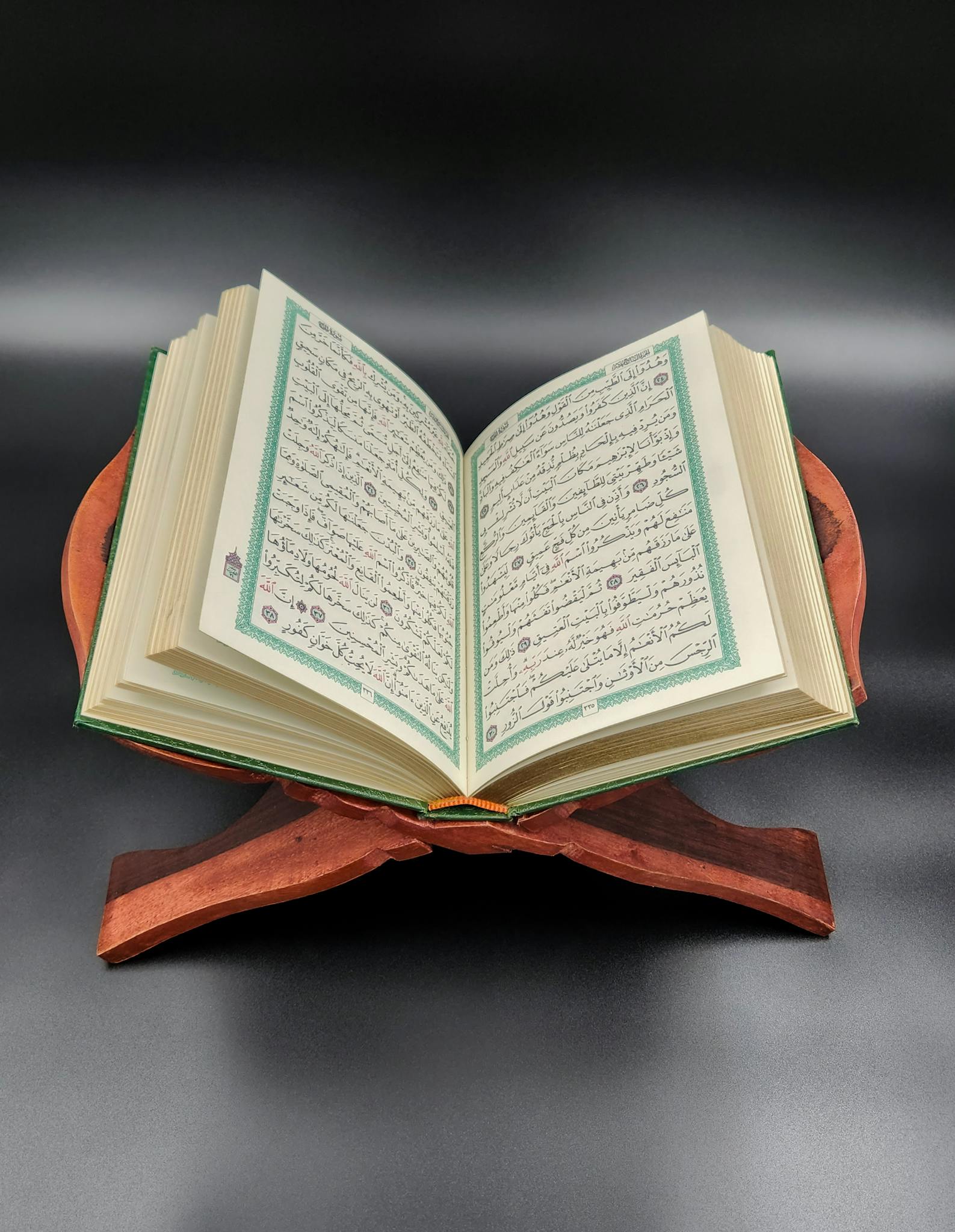 An open Quran placed on an ornate wooden stand, ideal for spiritual reflection and study.